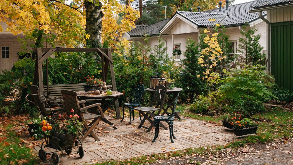 a patio with a table, chairs and a bench