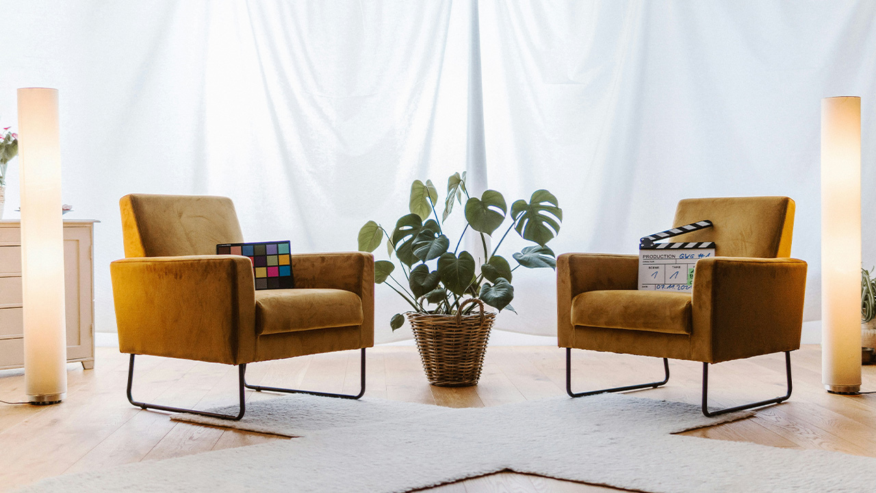 a living room with two chairs and a plant