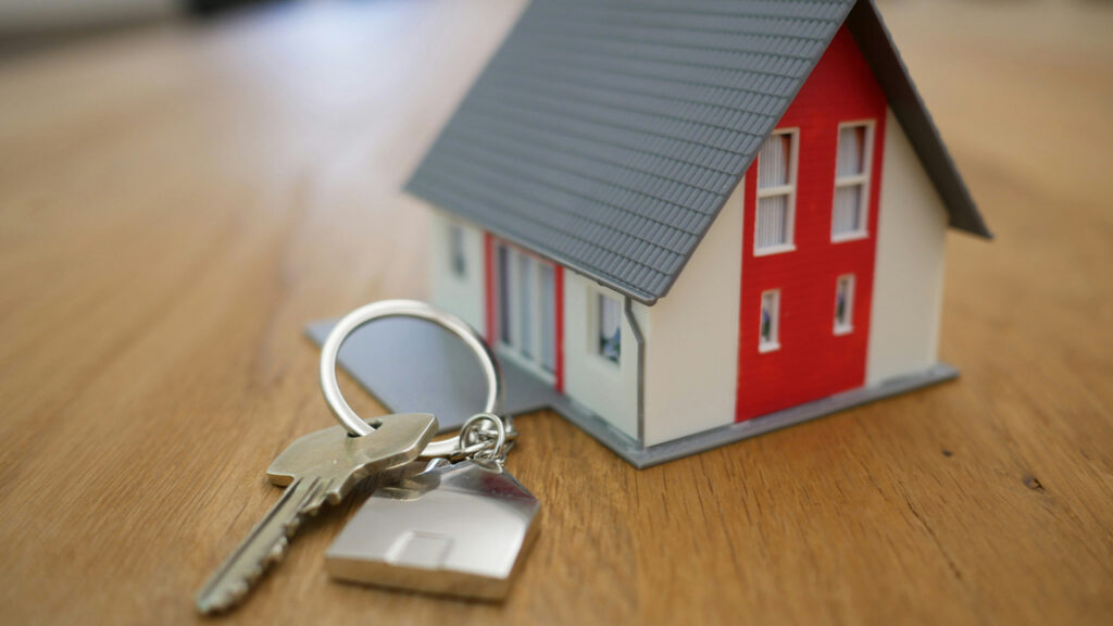 white and red wooden house miniature on brown table