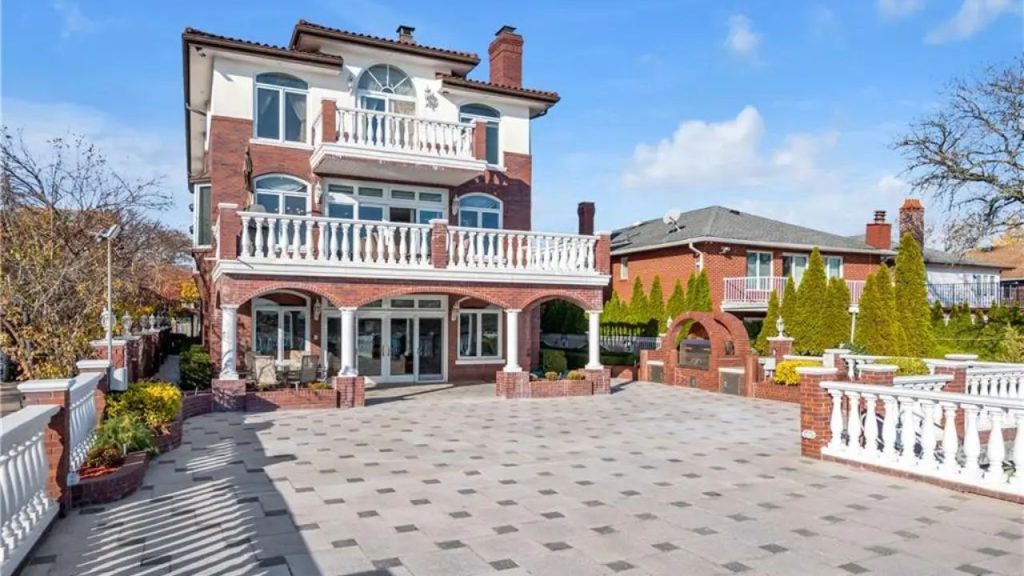 Elegant three-story brick home with balconies and a spacious courtyard.