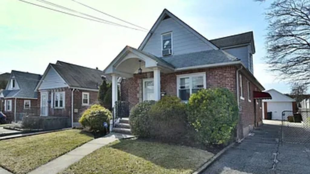 A classic brick home with a pitched roof, front porch, and well-kept yard.