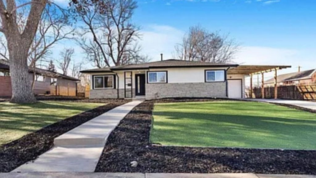 A modern single-story home with a landscaped front yard, paved walkway, and covered carport.