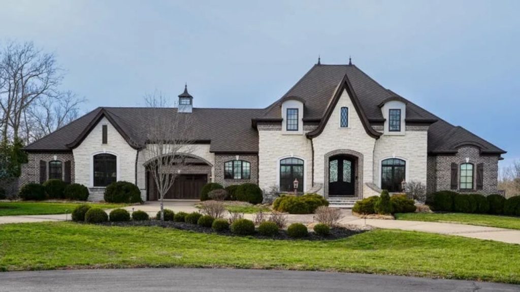 Gothic-inspired estate with stone and brick exterior, arched windows, and iron double door.