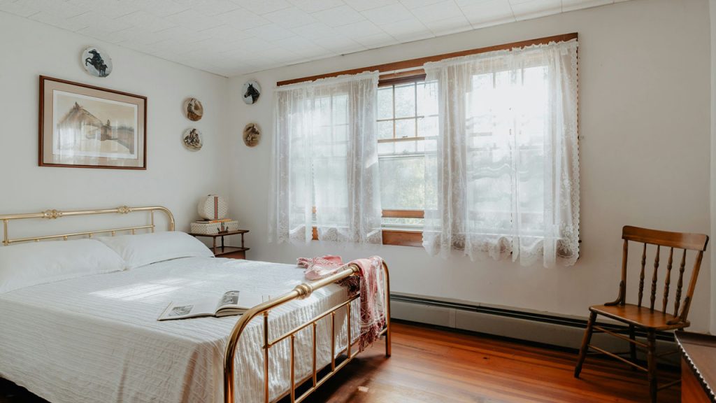 A bed sitting in a bedroom next to a window