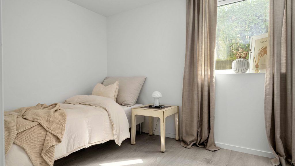 A bedroom with a bed and a window