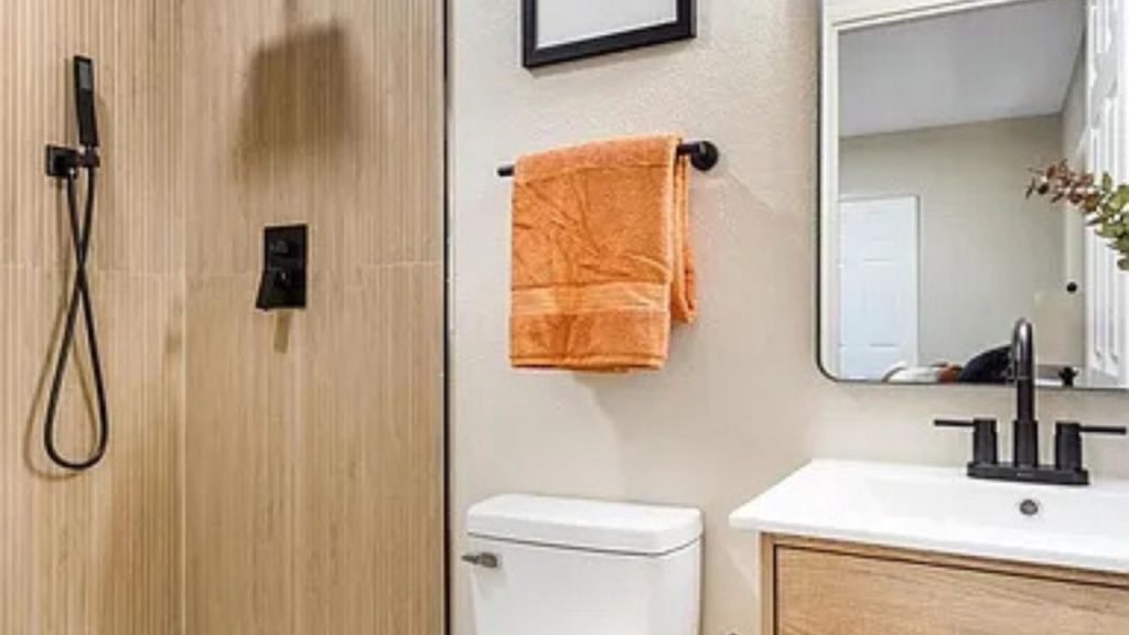 Modern bathroom with wood accents, black fixtures, and a floating vanity.