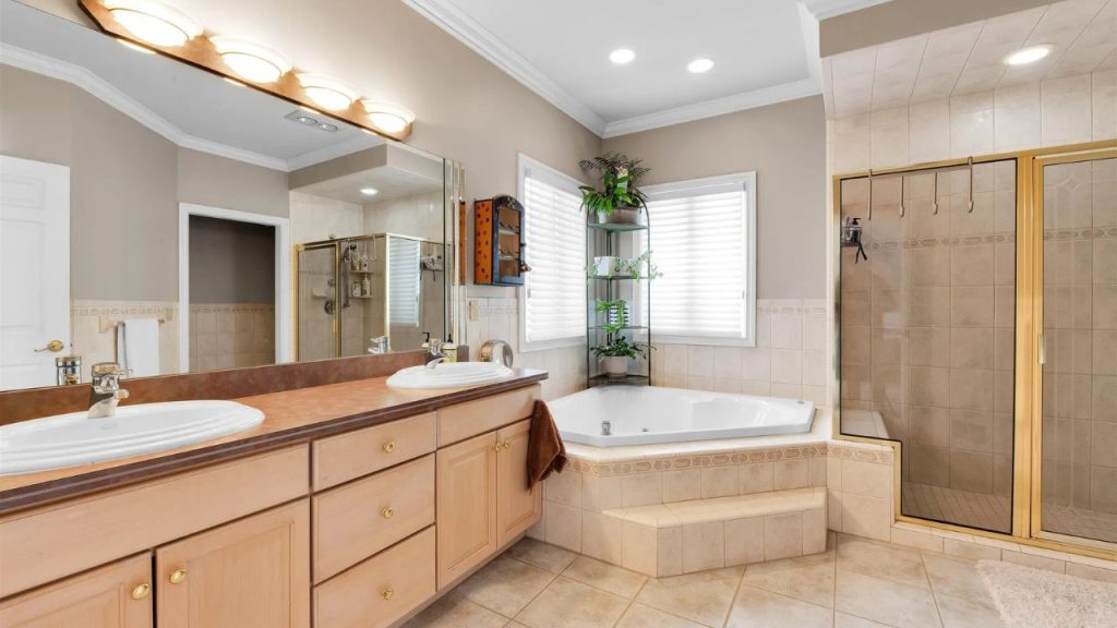 Spacious bathroom with a corner bathtub, dual sinks, and a glass-enclosed shower.