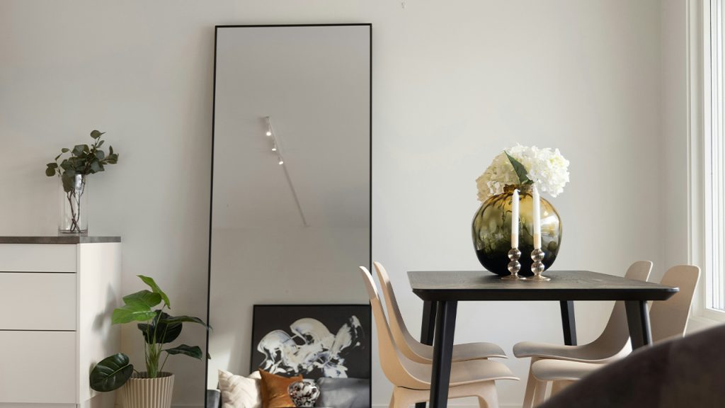 A room with a table, chairs, and a mirror