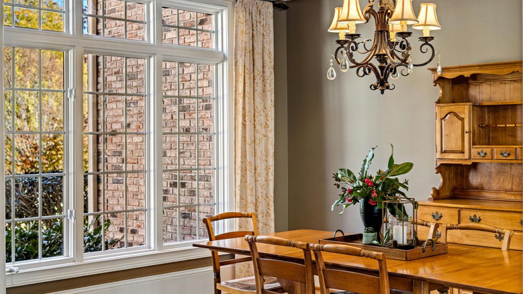 Brown Dining Table and Chairs beside White Framed Window