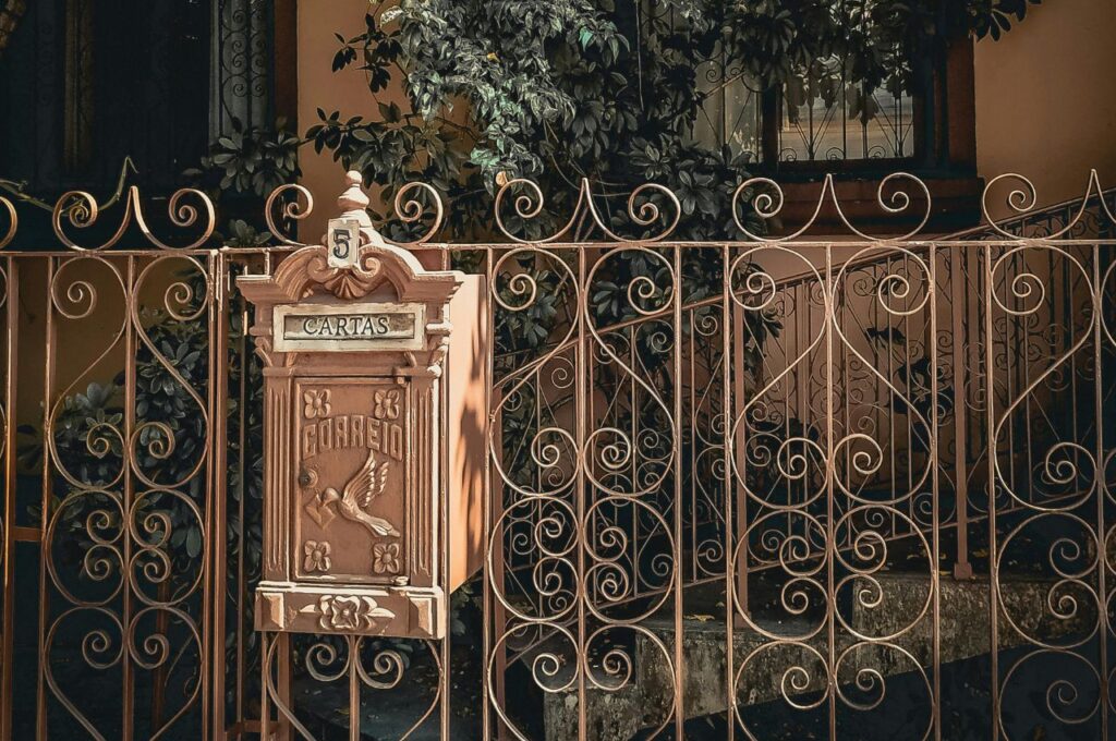 An iron gate with a mailbox.