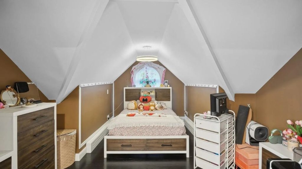 Cozy attic bedroom with sloped ceilings, warm brown walls, and a plush bed.