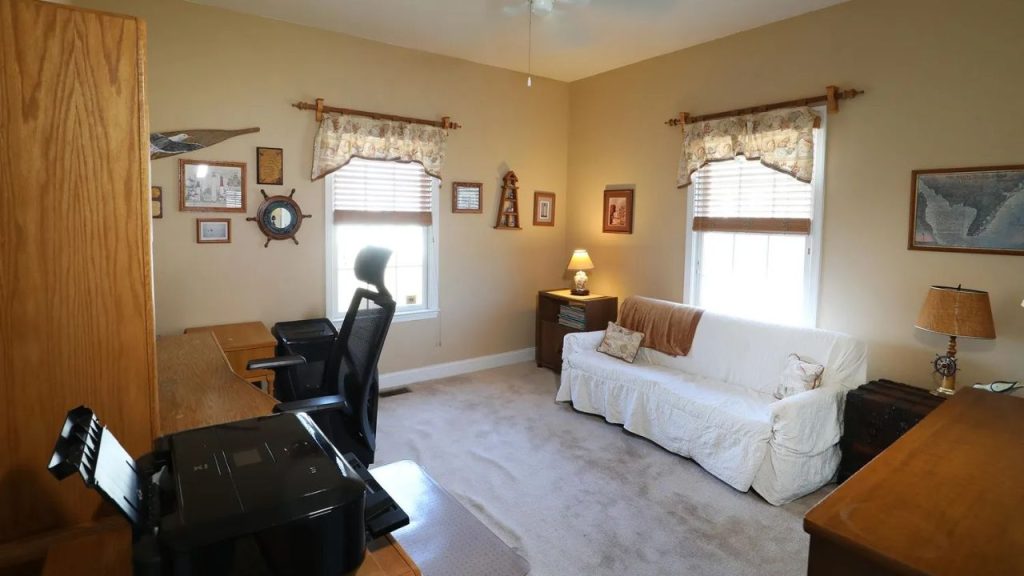 Cozy home office with a wooden desk, ergonomic chair, nautical decor, and a white sofa.

Would you like me to refine any details?