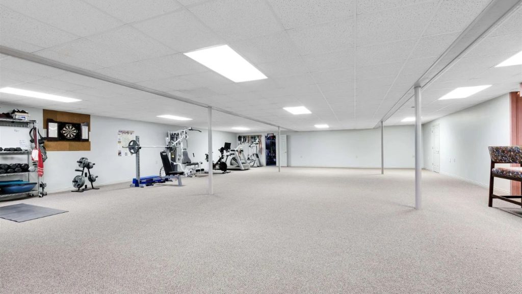 Spacious basement with home gym, exercise equipment, and open floor plan.
