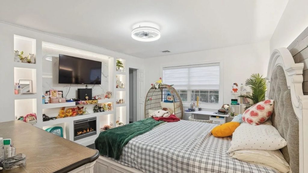 Stylish bedroom with built-in shelving, a fireplace, and a cozy egg chair.
