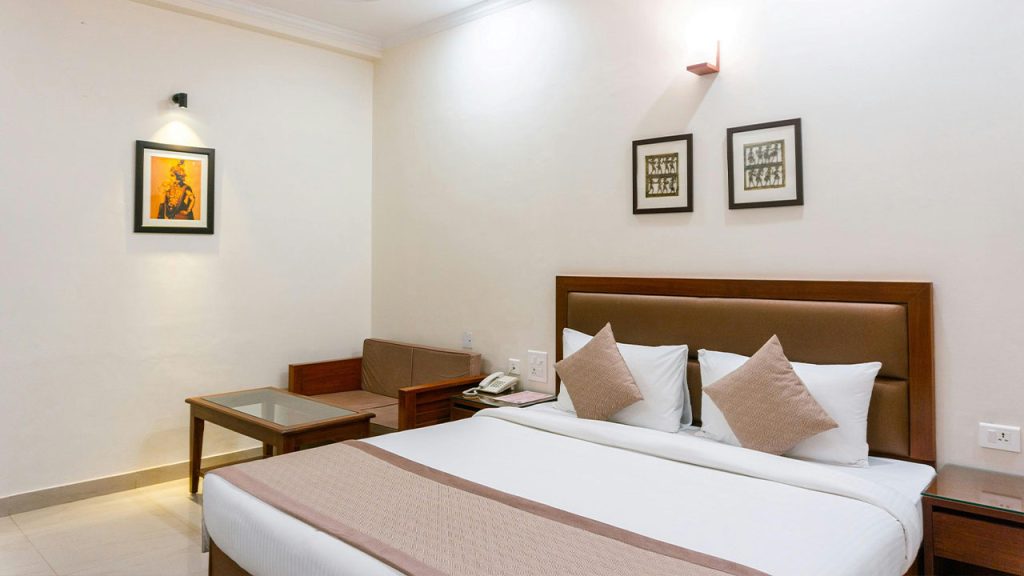 A Cozy Bed with Table and Couch on the Side