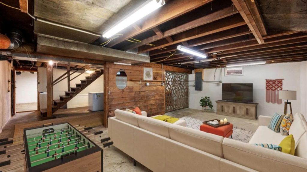 Cozy basement lounge with rustic wood accents and a foosball table.