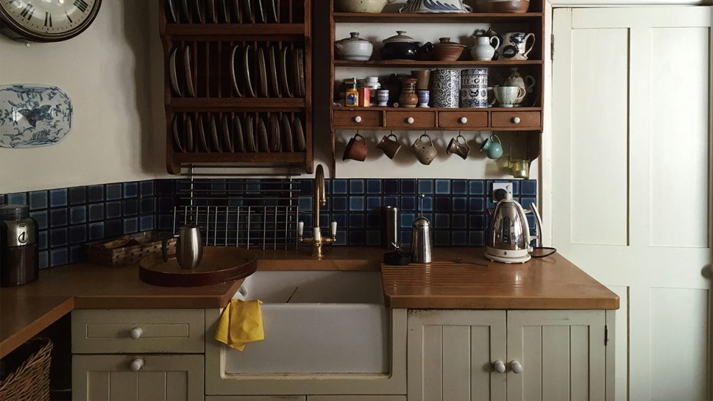 white kitchen cupboards and rack with dinnerware arranged on it