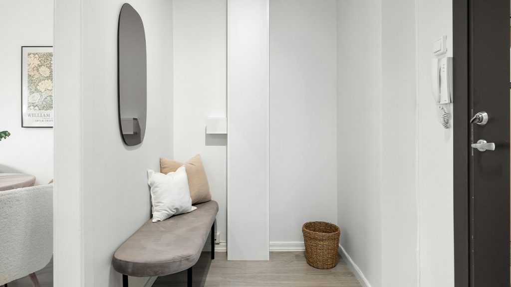 A hallway with a bench and a mirror