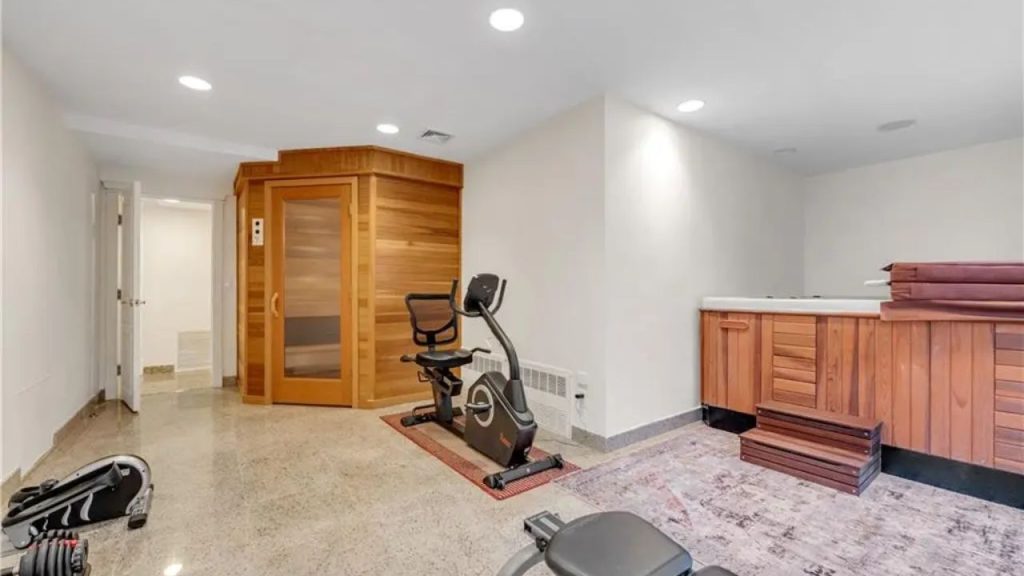 Home gym with a sauna, hot tub, and exercise equipment.