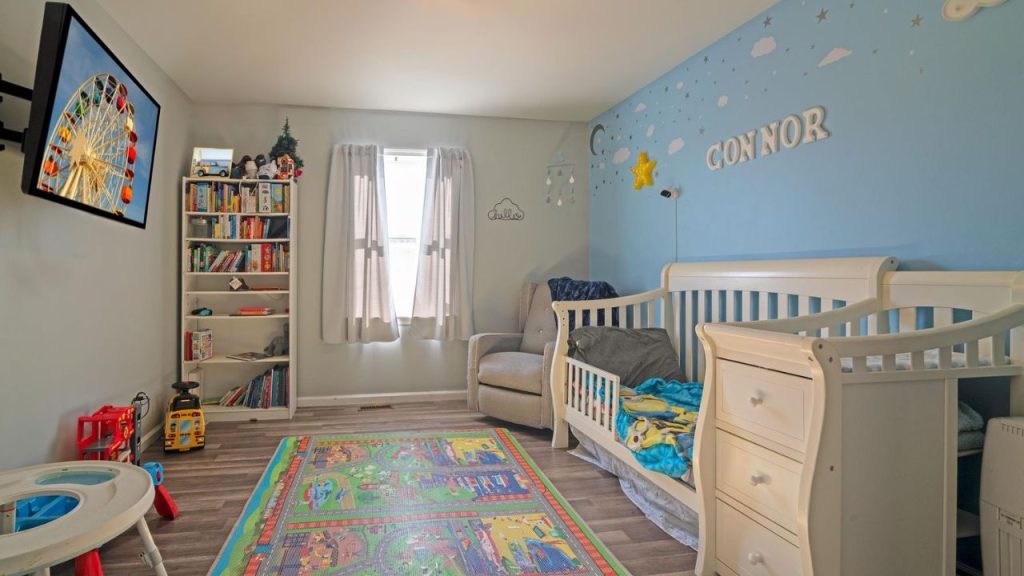 Cozy nursery with a white crib, blue accent wall, and playful decor.