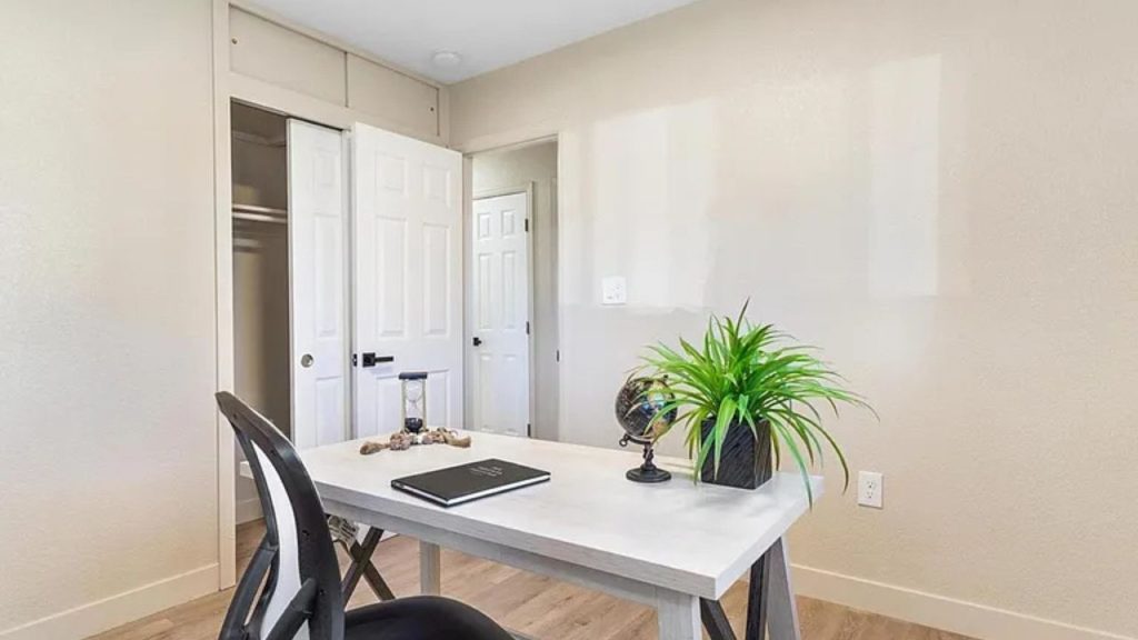 Minimalist home office with a sleek desk, black chair, and simple decor.