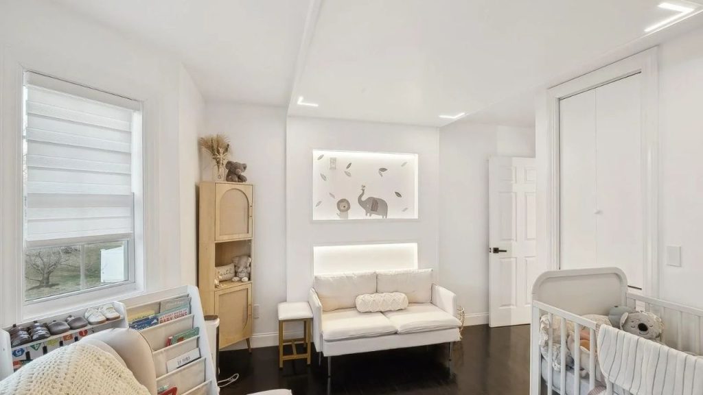 Cozy nursery with soft neutrals, a loveseat, and a crib in a well-lit space.