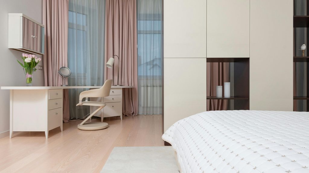 Interior of spacious bedroom with white furniture