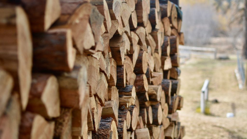 a large stack of logs sitting in a field