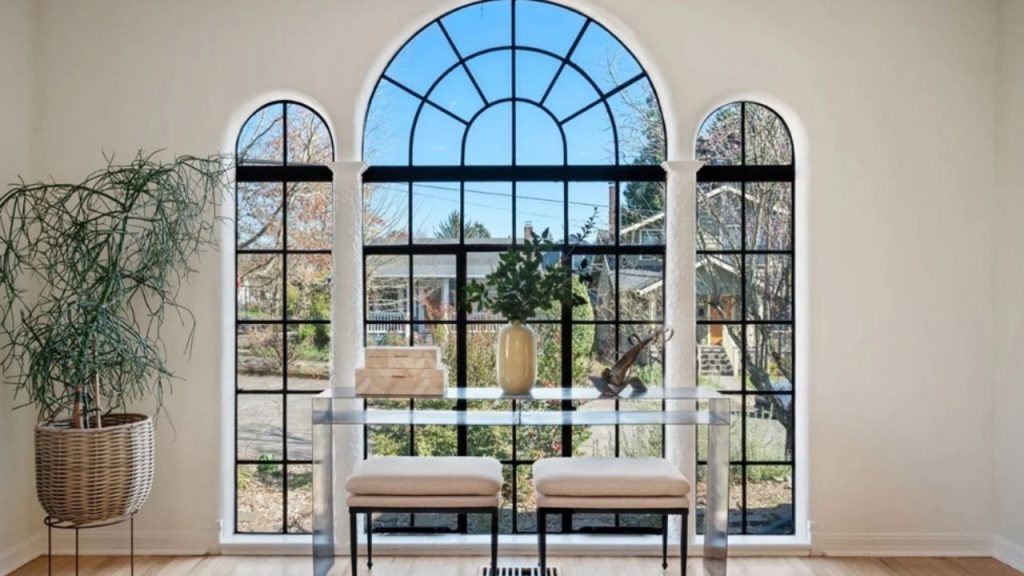 Bright sitting area with arched windows, a clear desk, and serene outdoor views.