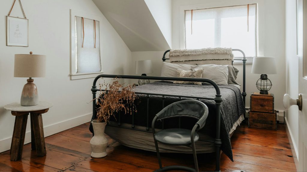 A bedroom with a bed and a chair in it