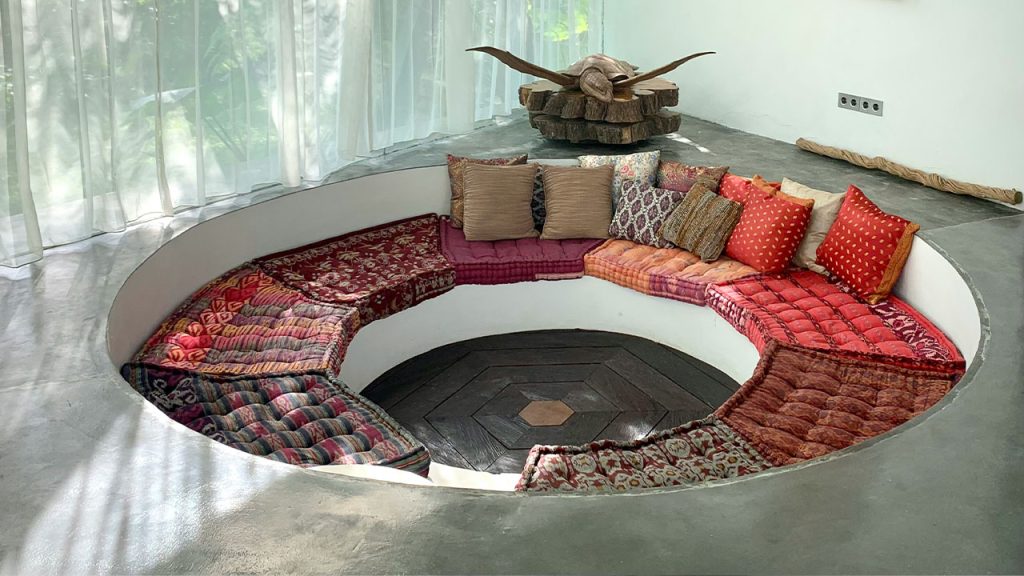 a circular couch with a lot of pillows on top of it