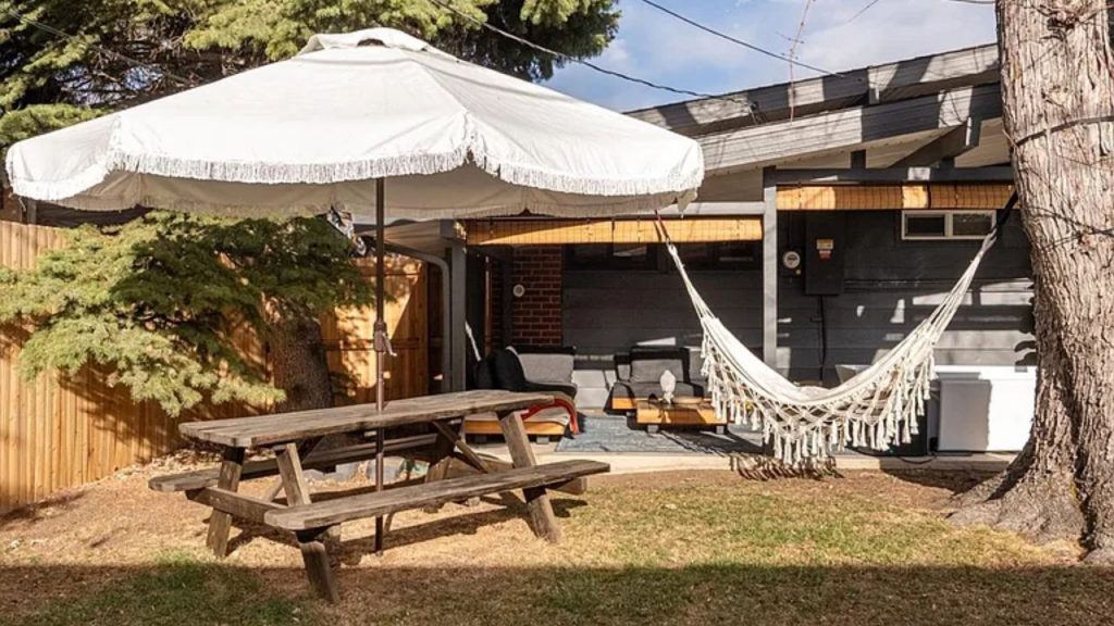 Cozy backyard with a picnic table, hammock, and shaded patio seating.
