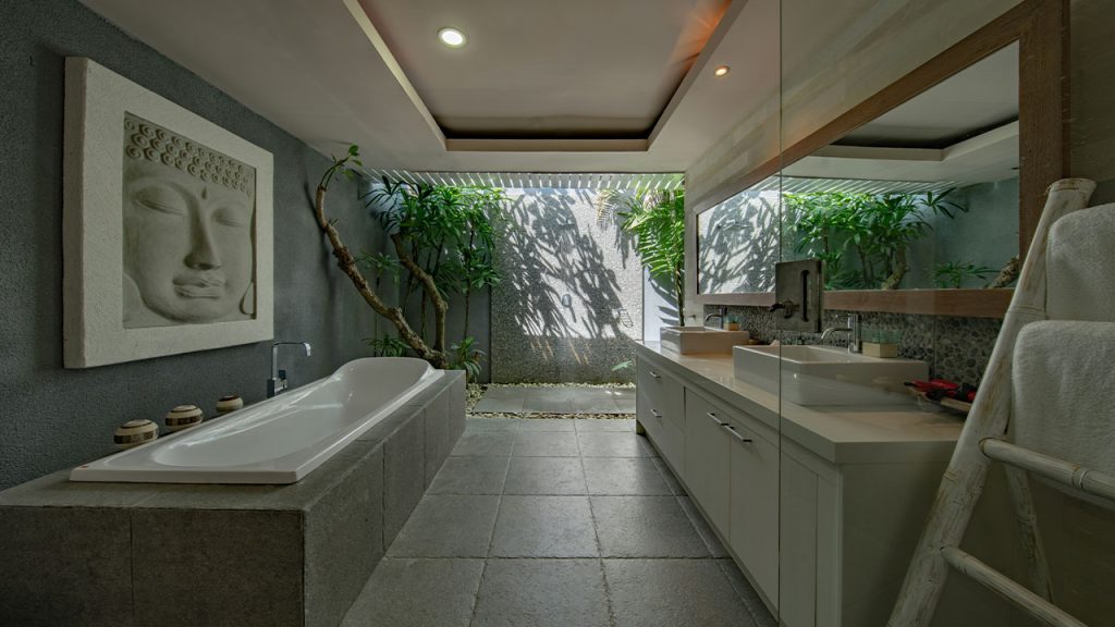white ceramic bathtub beside gray wall