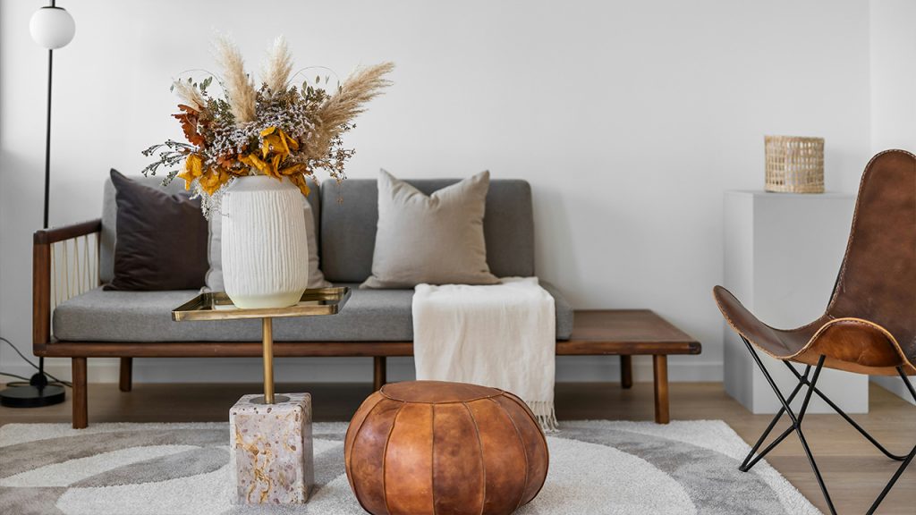 A living room with a couch, chair, table and vase of flowers