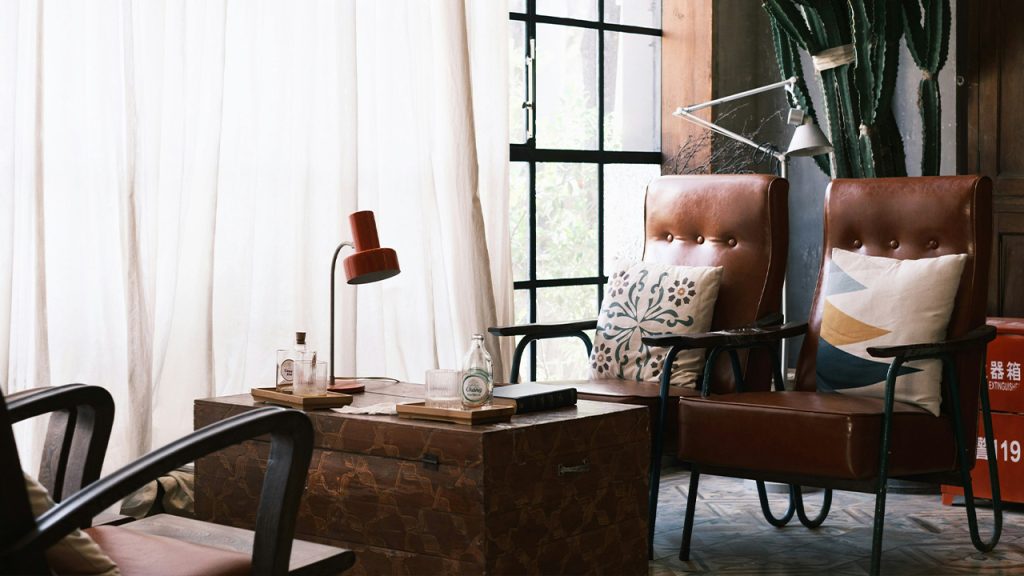 brown wooden table near brown and white floral armchair