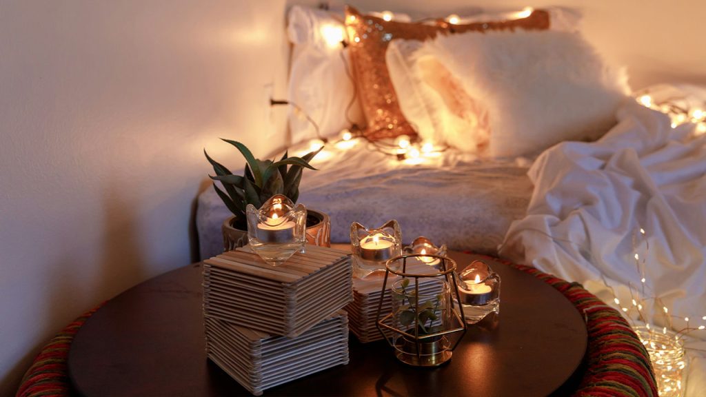 a cozy boho room decor with candles and string lights