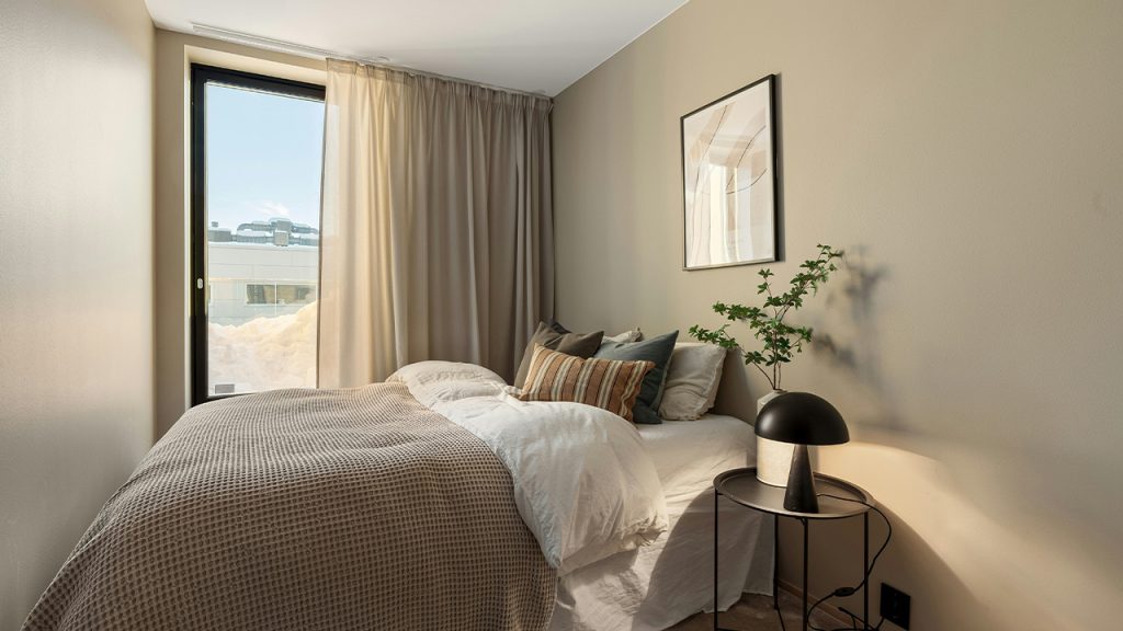 A bedroom with a bed and a large window