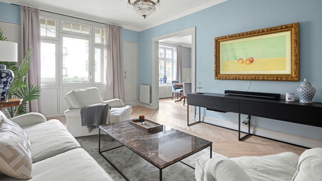 A living room filled with furniture and a painting on the wall