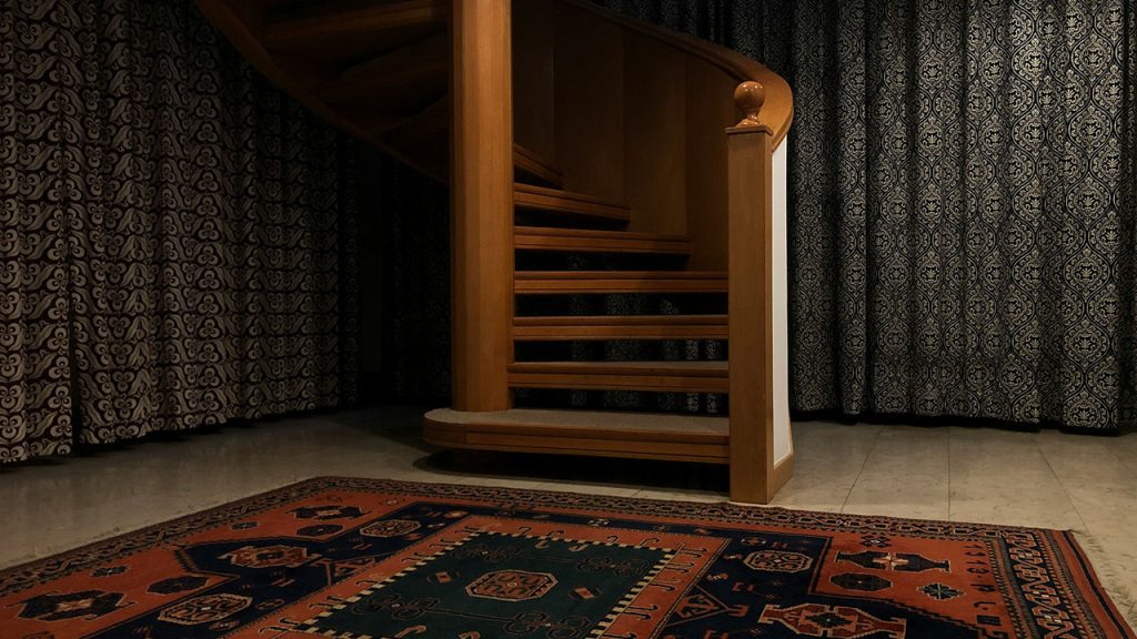 a spiral staircase in a house with a rug on the floor