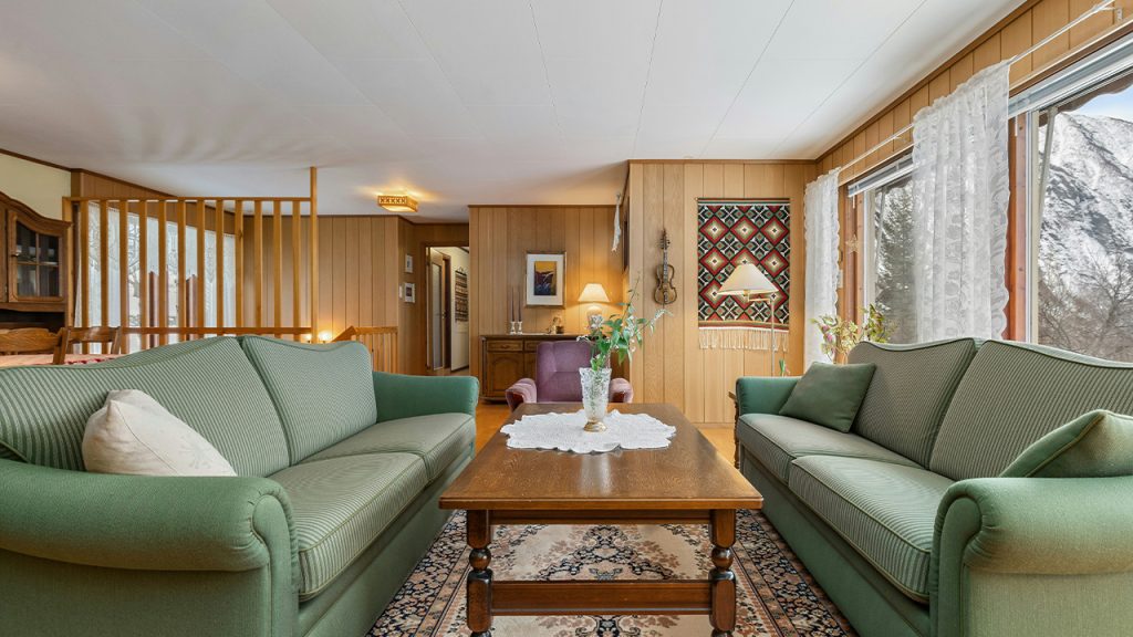 A living room filled with green couches and a coffee table