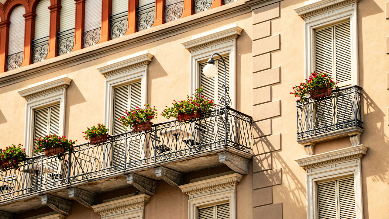a building with a balcony and flower boxes on the balconies