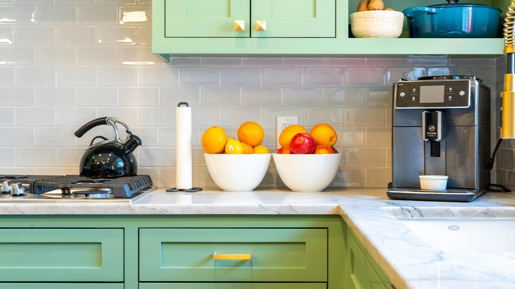 a kitchen with green cabinets and white counter tops