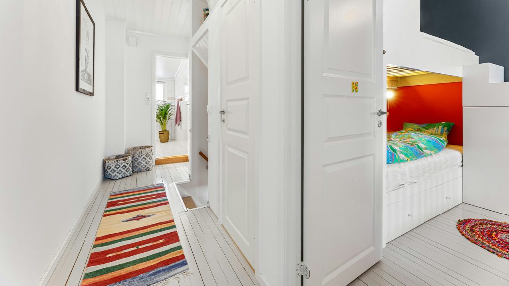 A hallway with a bed and a rug on the floor