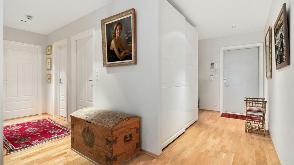 A white room with a wooden trunk in the corner