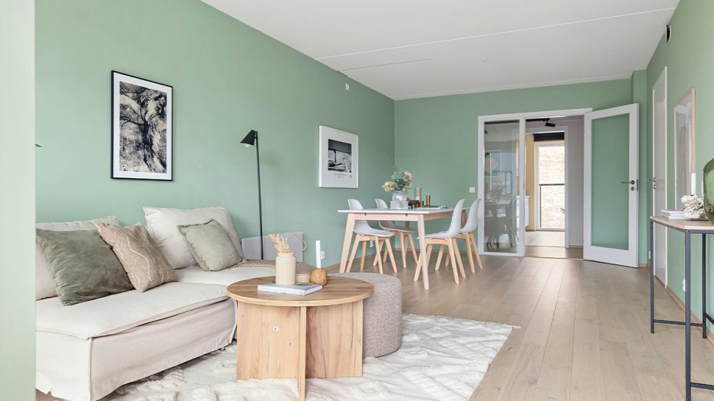 A living room filled with furniture and green walls