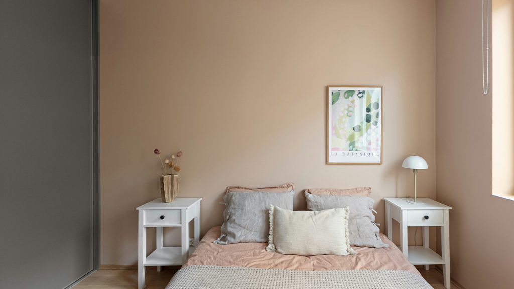 A bed sitting in a bedroom next to a window