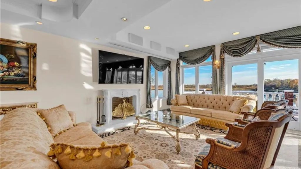 Elegant living room with gold décor and a waterfront view.