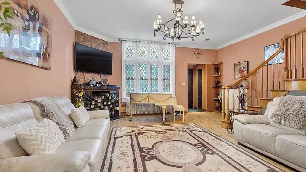 Elegant living room with a marble fireplace, leaded-glass windows, and a grand chandelier.