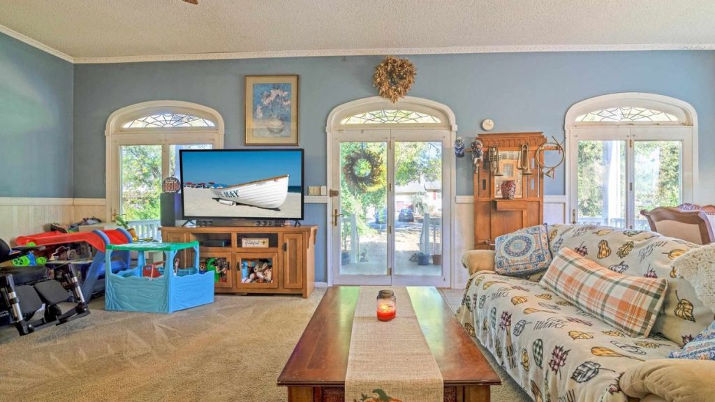 Cozy living room with French doors, arched windows, and a mix of traditional and playful decor.