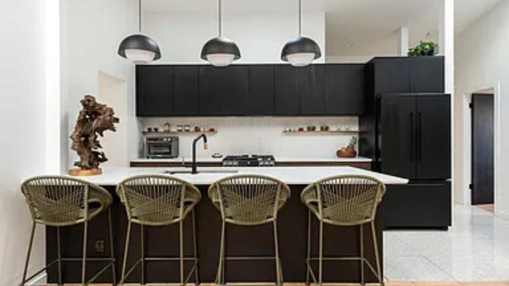 Modern black-and-white kitchen with woven barstools and pendant lighting.